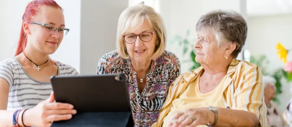 Drei Menschen vor dem Tablet