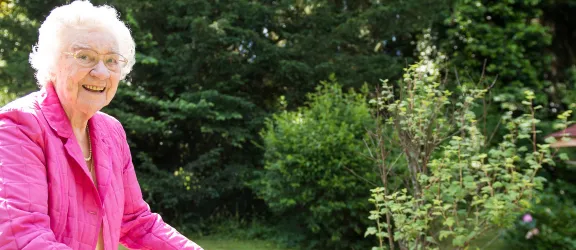 Bewohnerin des Seniorenhiem Lenzheim mit Rollator im Garten