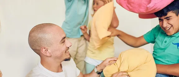 Kissenschlacht mit einem Betreuer und zwei Kindern