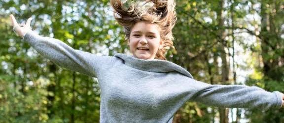 Jugendliche springt im Garten der heilpädagogischen Tagesstätte Rummelsberg in die Luft 