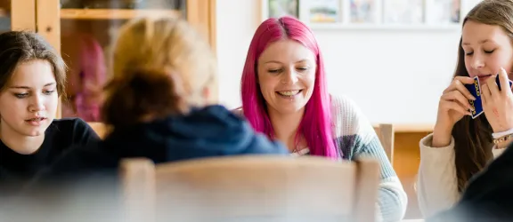 Jugendliche und Pädagogin der Jugendhilfe Nördlingen unterhalten sich am Tisch