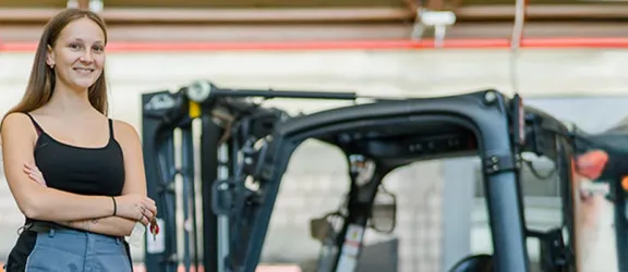 Auszubildende fährt mit dem Gabelstapler