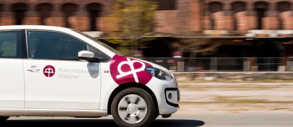Weißes Auto mit Aufdruck der Rummelsberger Diakonie
