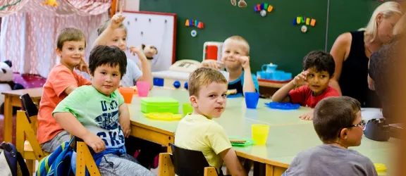 Viele Kinder sitzen an einem Tisch der Grundschule des Förderzentrums