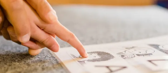 Heilerziehungspflegerin hilft Kind beim Arbeitsblatt