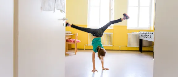 Mädchen im Kinderhort schlägt ein Rad