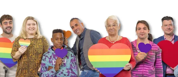 Viele Menschen nebeneinander mit Herzen in der Hand