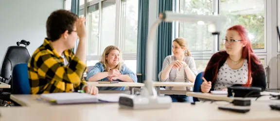 Schüler*innen und Lerhrerin im Klassenzimmer der Berufsschule zur sonderpädagogischen Förderung