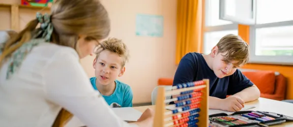 Zwei Schüler lernen mit Sonderschulpädagogin