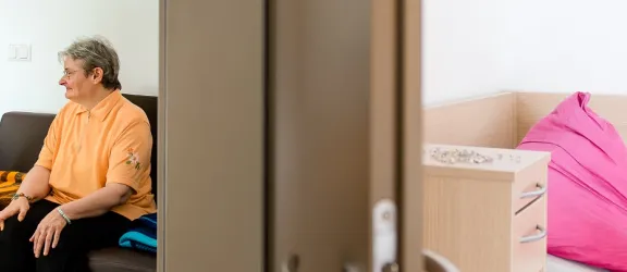 Zwei Menschen sitzen auf einem Sofa und lachen