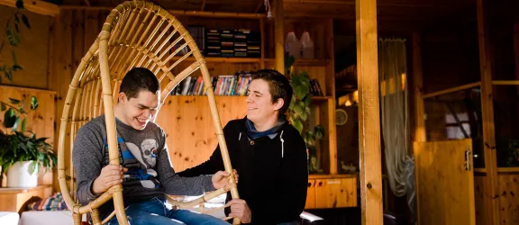 Heilerzieher in der Ausbildung neben Jungen mit Behinderung im Sessel