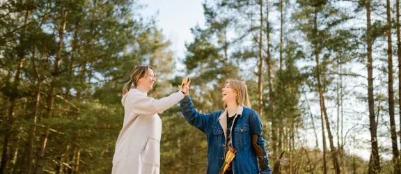 Erzieherin und Jugendliche beim Bogenschießen