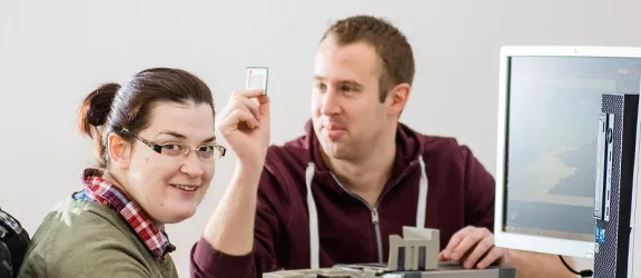 Eine Frau und ein Mann mit Behinderung vor einem Bildschirm im Copyshop Altdorf