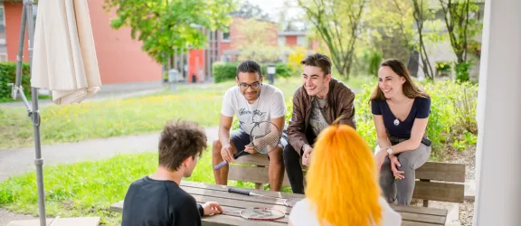 Jugendliche mit und ohne Migrationshintergrund um Tisch sitzend im Projekt Powerbank