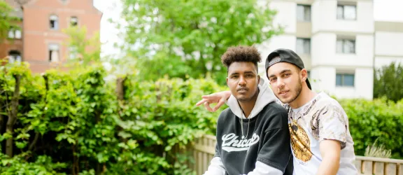 Zwei junge Geflüchtete mit Lehrerin beim Deutschkurs in der Clearingstelle