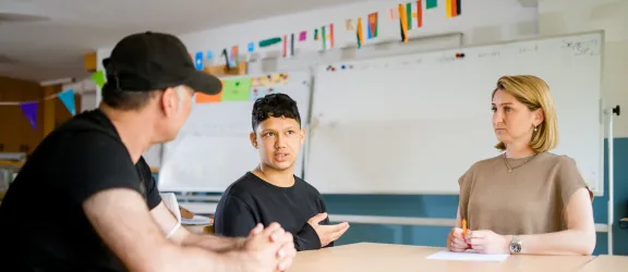 Jugendlicher mit Therapeutin und Übersetzer im Gespräch