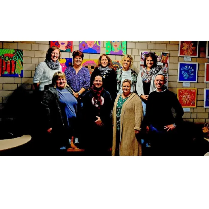 Neun Mitglieder des Elternbeirats stehen vor einer Wand