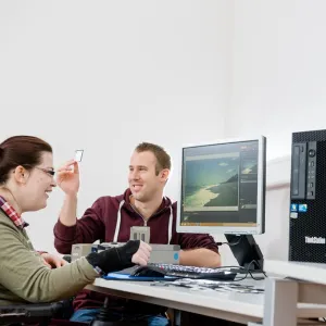 Zwei Menschen sitzen vor einem Computer