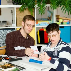 Zwei Menschen sitzen an einem Tisch