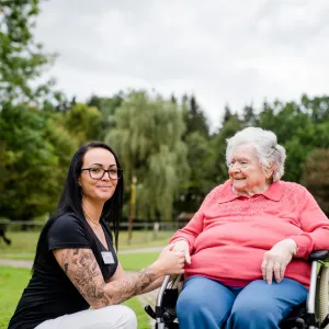 Mitarbeitende in der Pflege mit Seniorin