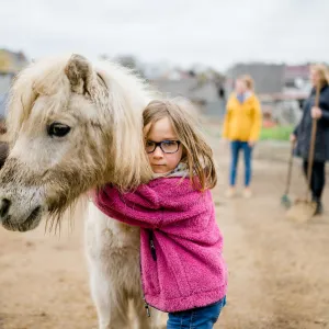 Mädchen umarmt Pferd