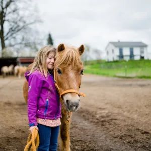 Mädchen umarmt Pferd