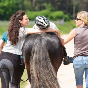 Kind sitzt auf Pferd.