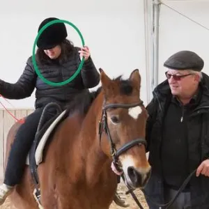 Kind sitzt auf Pferd.