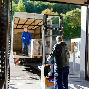 Eine Person belädt einen LKW