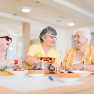 Drei Frauen schneiden Obst im Seniorenzentrum