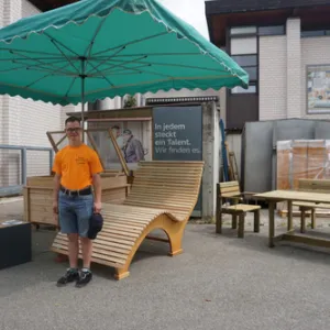 Mann steht vor Holzliege