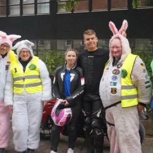 Sechs Menschen in lustigen Motarradkostümen lachen in die Kamera