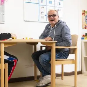 Zwei Männer sitzen an einem Tisch und spielen etwas