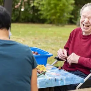 Ein Mann sitzt am Tisch im Garten