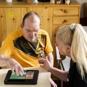 Zwei Menschen sitzen am Tisch und spielen