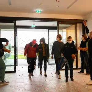 Sieben Menschen stehen im Eingangsbereich