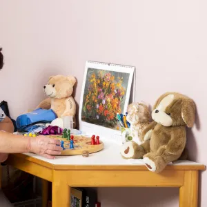 Frau sitzt an einem Tisch mit Plüschtieren