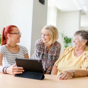 Drei Frauen am einem Laptop im Quartiersmanagement
