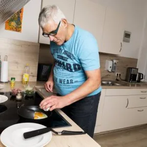 Ein Mann kocht in der Küche am Herd