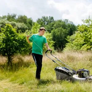 Ein Mann schiebt einen Rasenmäher