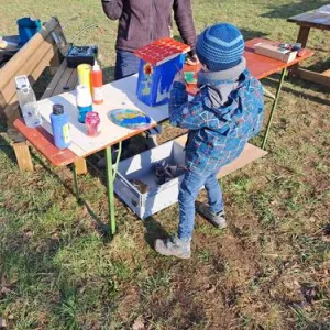 Ein Kind bemalt einen Nistkasten