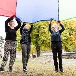 Drei Frauen halten Tuch in die Höhe