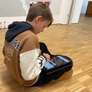 Junge mit Tablet auf dem Boden sitzend
