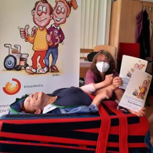 Eine Pflergerin und eine Person auf einer Liege