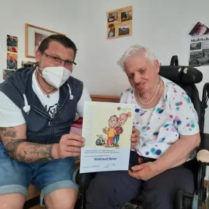 Pfleger mit Frau im Rollstuhl