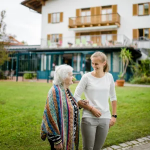 Seniorin und Besucherin vor Parkwohnanlage