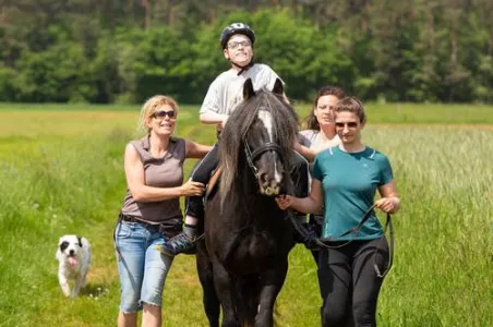 Kind sitzt auf Pferd.