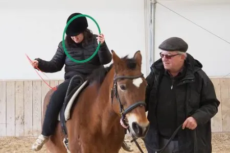 Kind sitzt auf Pferd.