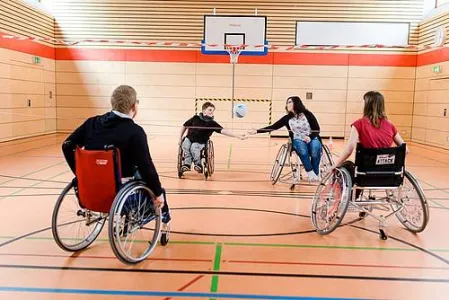 Vier Menschen im Rollstuhl in der Turnhalle