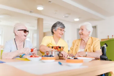 Drei Frauen schneiden Obst im Seniorenzentrum